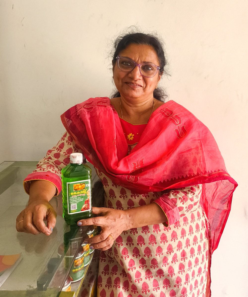 Subi Prince, founder of Kairali, holding a bottle of Kairali Coconut Milk Oil at the VKP Industries unit